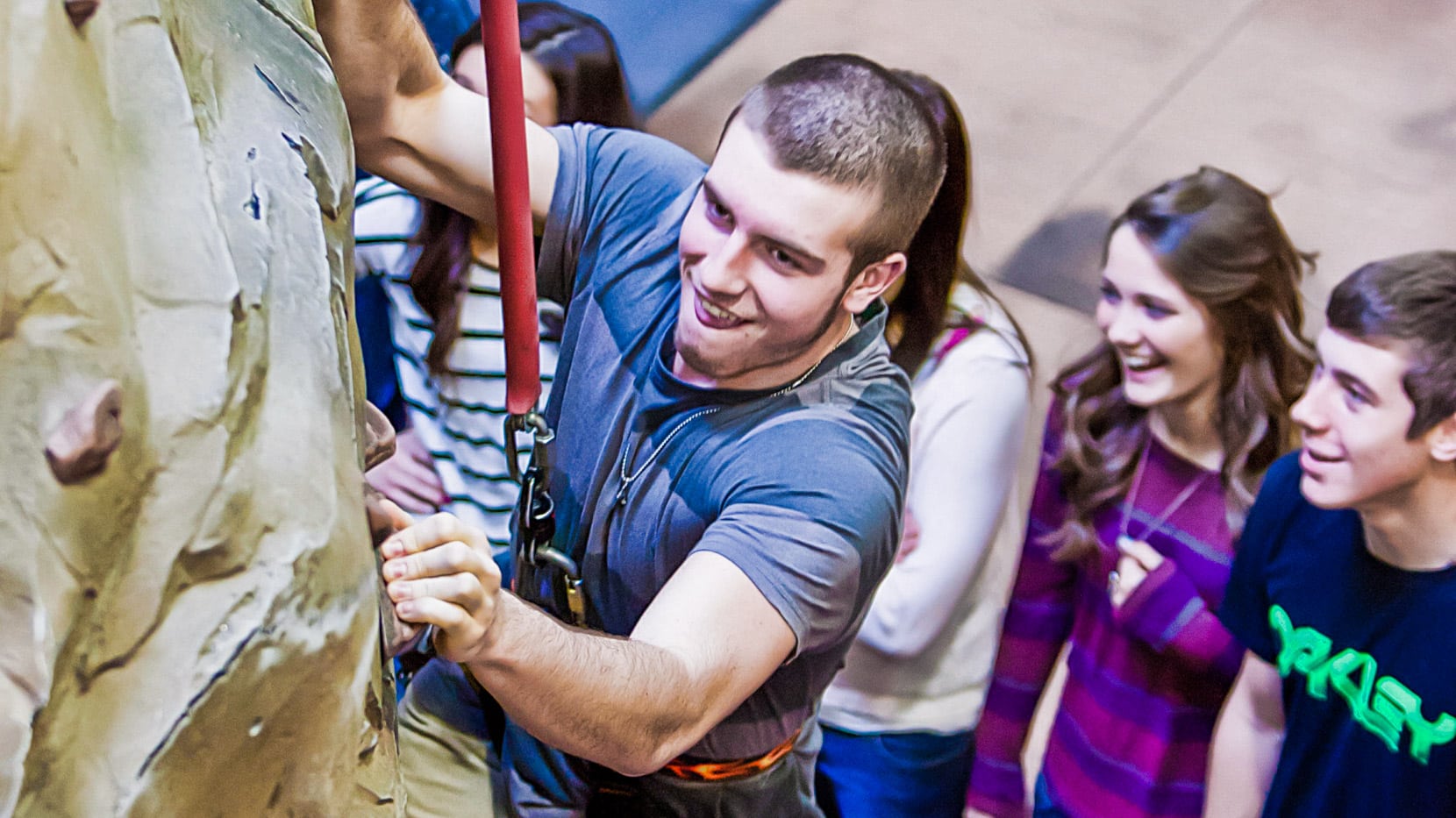 Young man climbing the rock wall