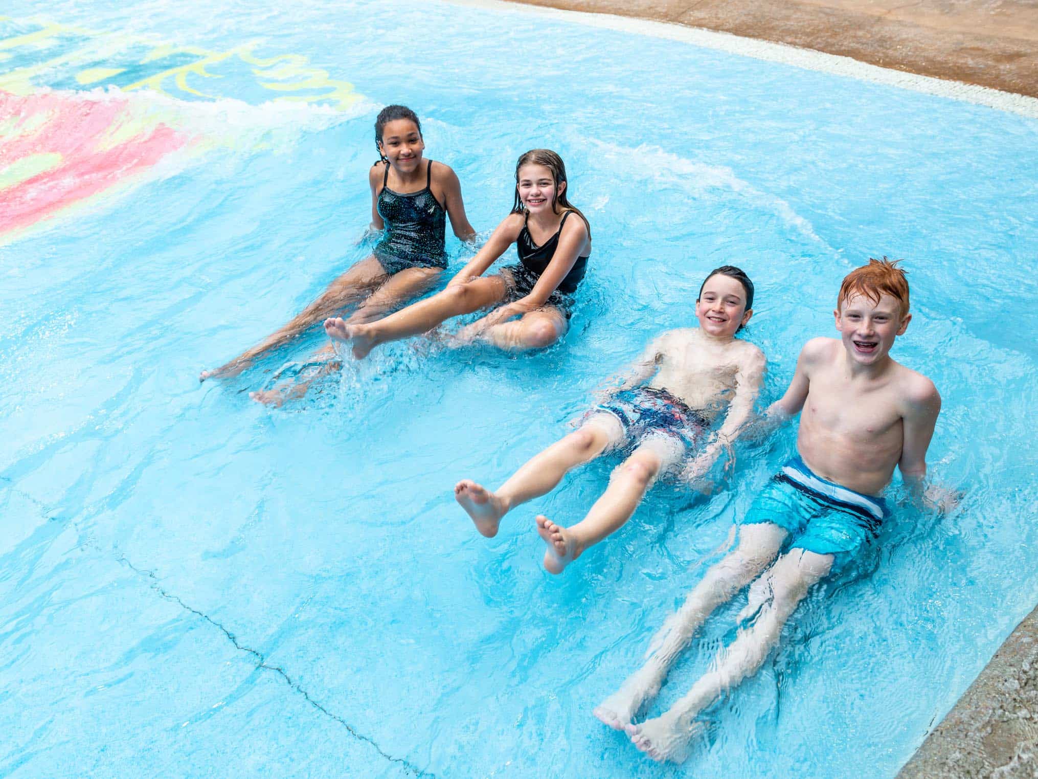 Four young friends sitting in the wave pool