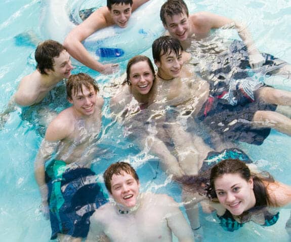 Group of young adults gathered in a pool having fun